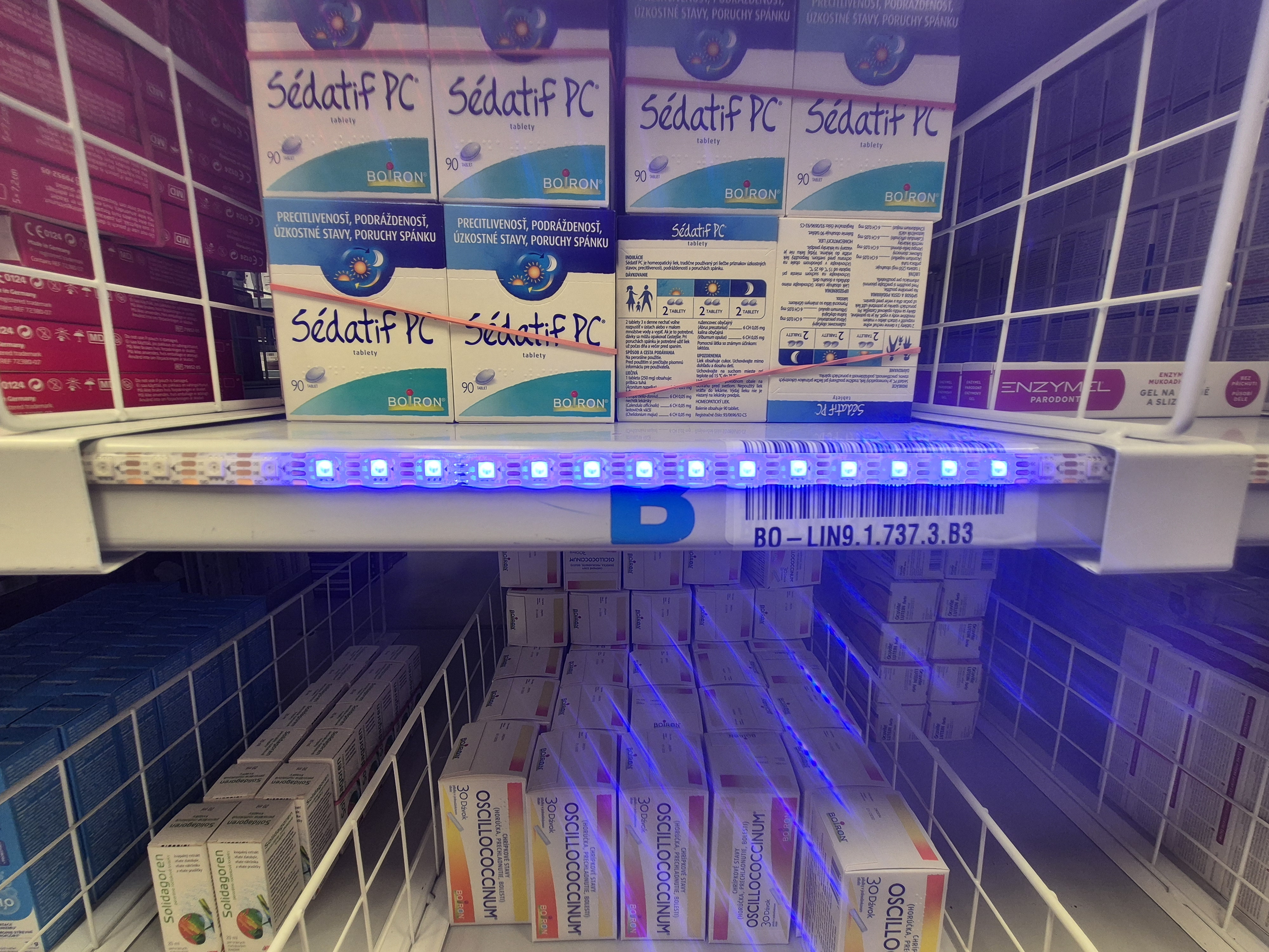 Detail modro svietiaceho LED pásu na hrane regála